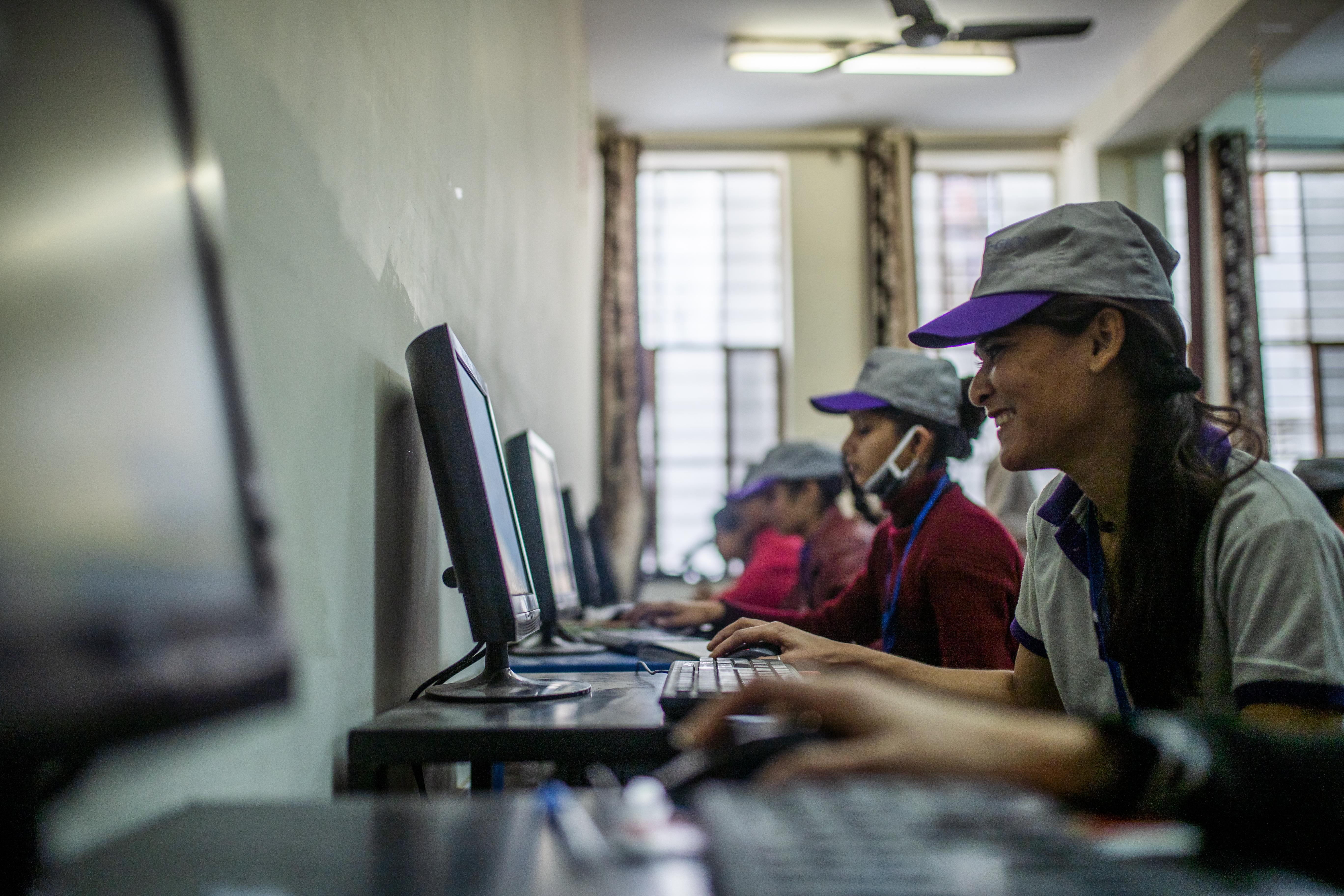 young women sat in front of desktop computers working